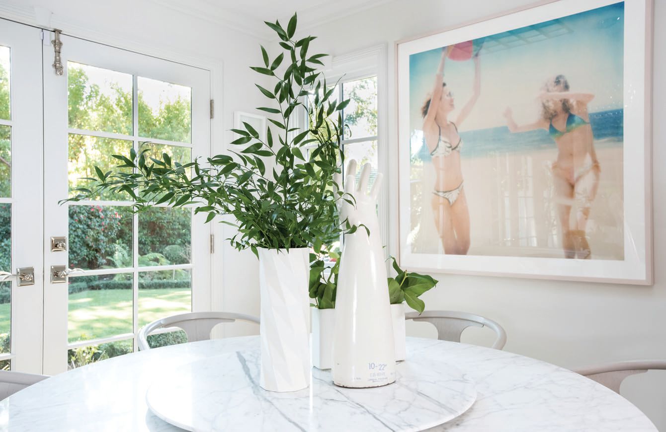 In the breakfast room, double French doors open to a lush back garden. A marble-top Saarinen dining table sits next to a photograph by artist Stefanie Schneider PHOTOGRAPHED BY CHRISTOPHER STARK