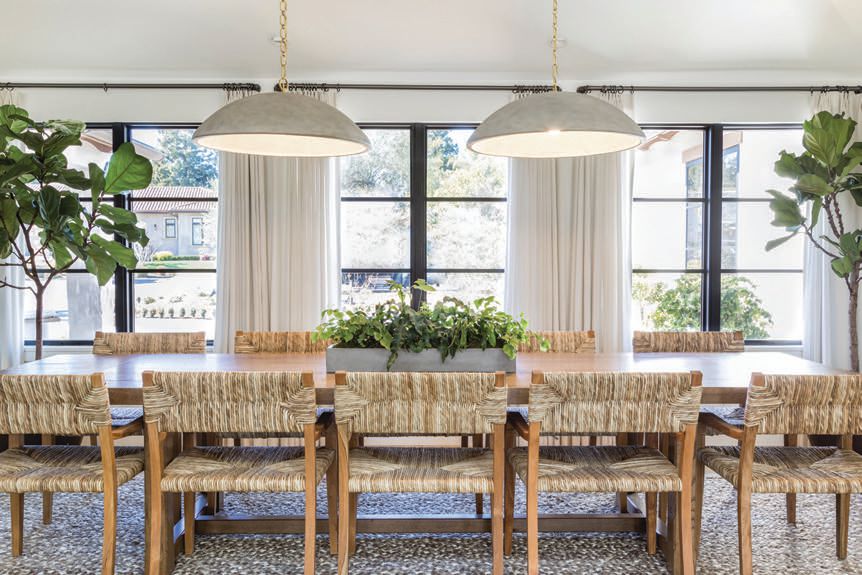 The main home’s dining room houses Merwin pendants and Halston dining chairs from Pure Salt Shoppe and simple drapes from The Shade Store. PHOTOGRAPHED BY VANESSA LENTINE